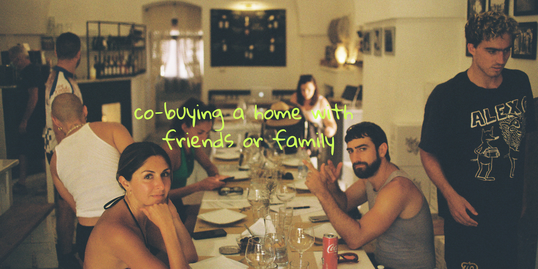 Friends sitting at a long table looking at the camera